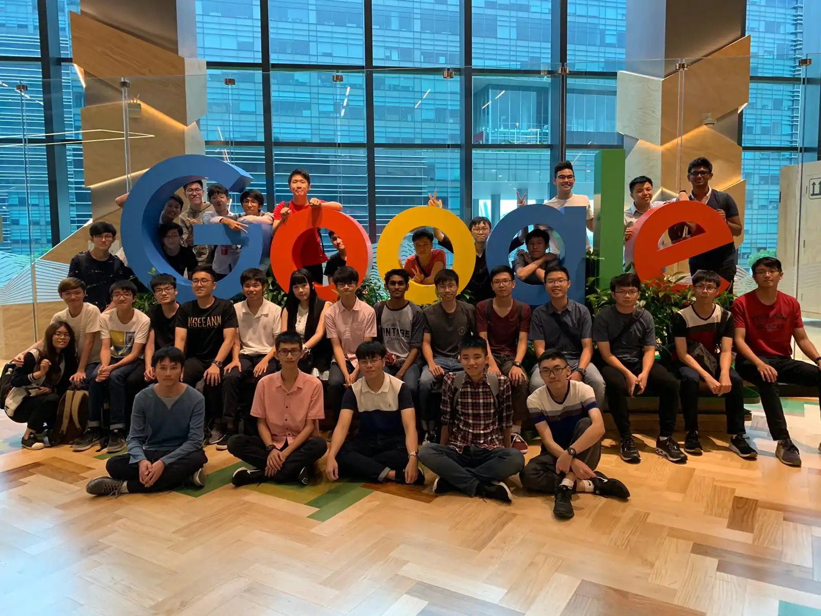 A group of people sitting in a room, with the words "Google" in the middle.