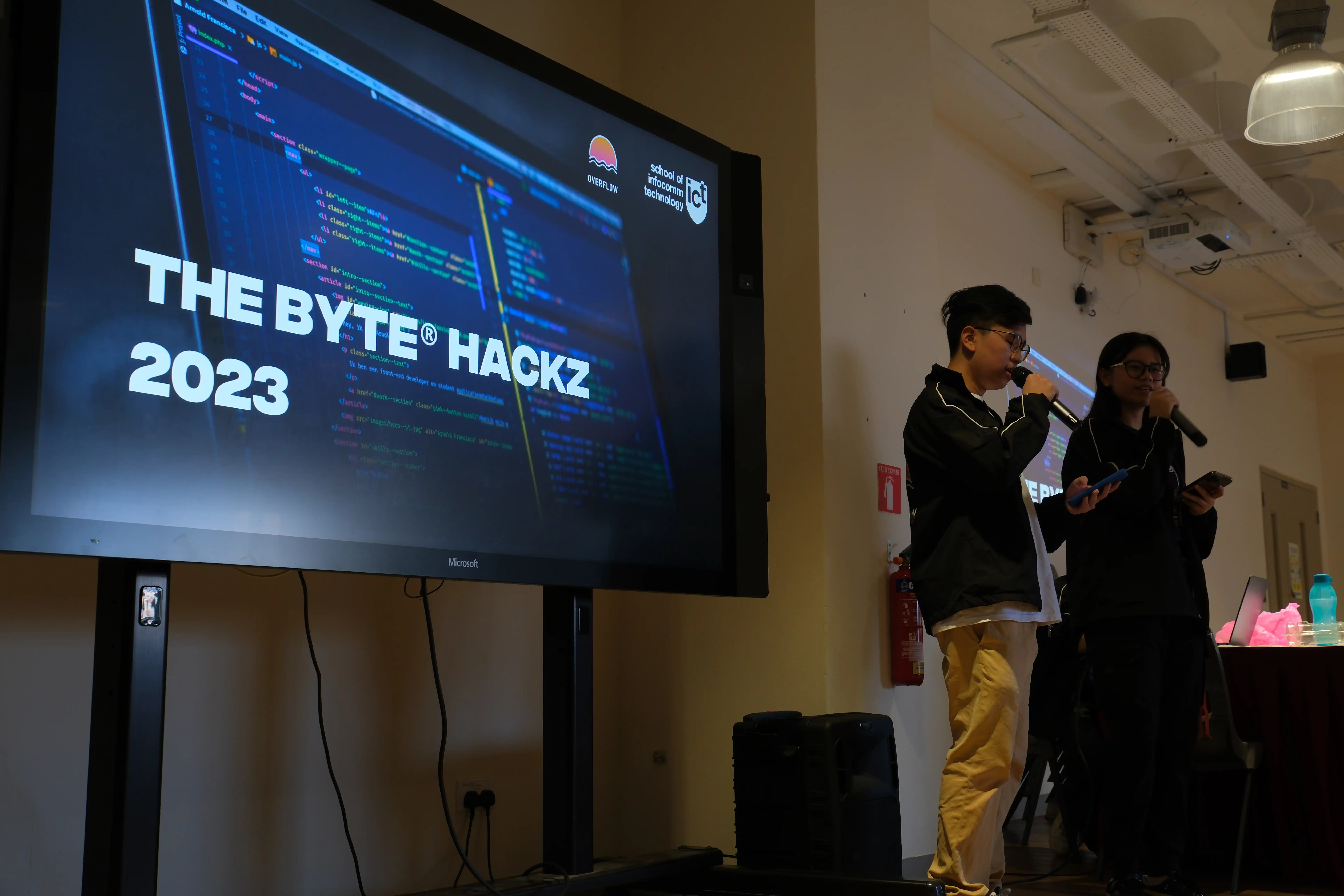 A large screen with the words "The Byte® Hackz 2023" on it, with two speakers to the right.